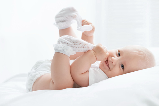 Baby-smiling-and-holding-feet